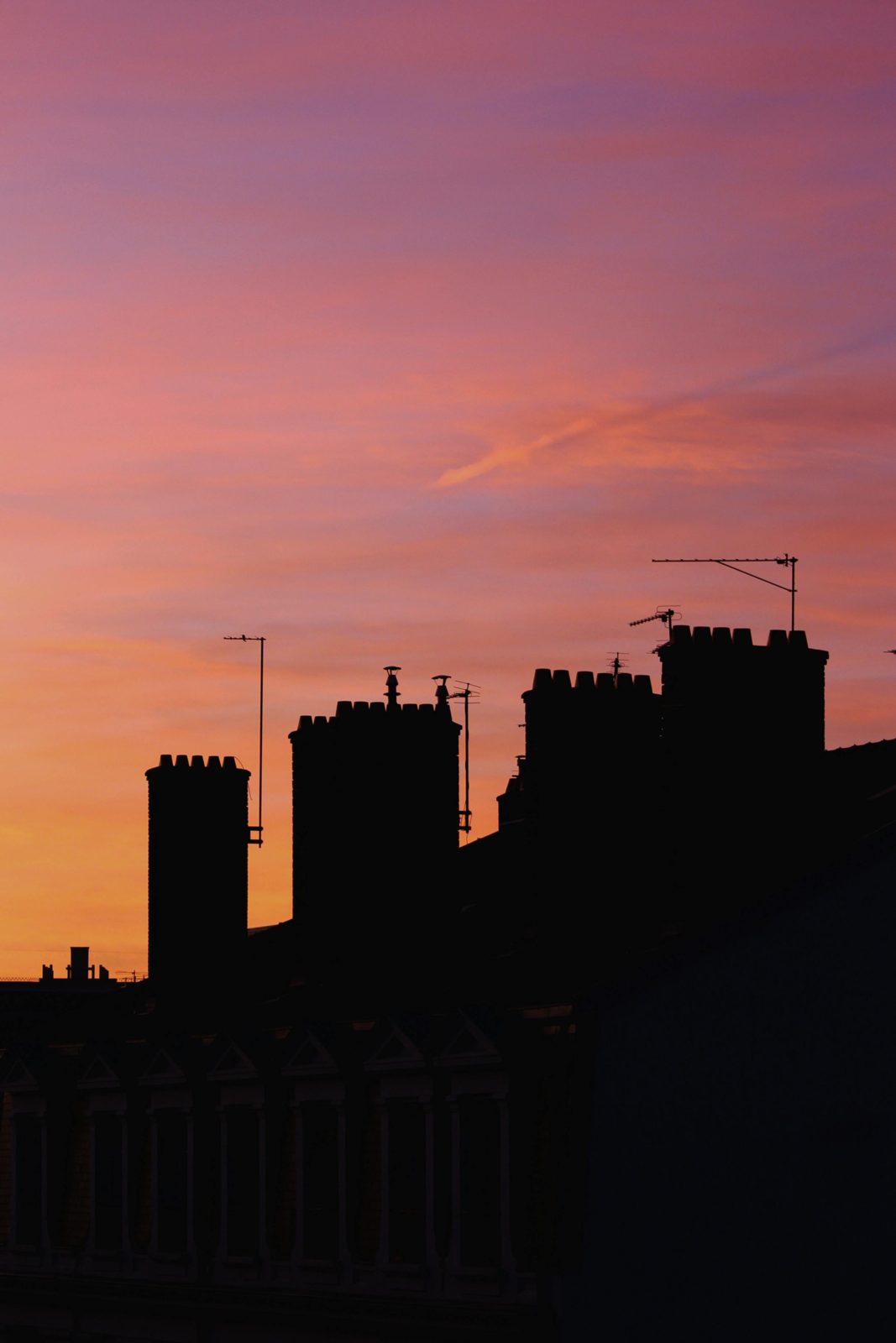 Silhouette de la ville et d'une grue de chantier au coucher du soleil
